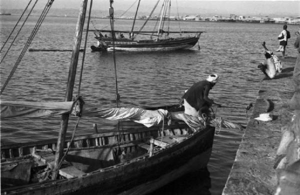 Viaggio in Africa. Massaua: scorcio del porto, la banchina, il bacino e imbarcazioni a vela ormeggiate alla fonda