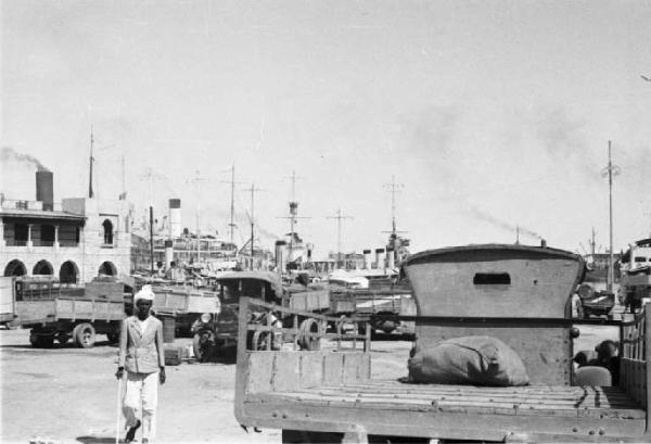 Viaggio in Africa. Massaua: scorcio del porto con autocarri militari italiani e piroscafi sullo sfondo
