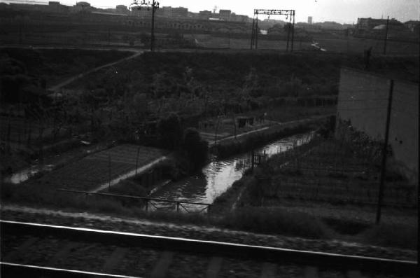 Periferia di Milano: un canale e orti di guerra visti dalla massicciata della ferrovia