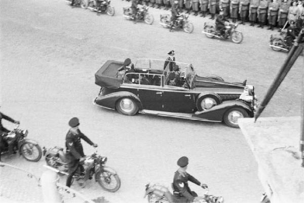 Patti di Roma. Piazza del Quirinale: ripresa dall'alto delle macchine componenti il corteo diplomatico, affiancate da motociclisti, che sfilano tra militari schierati