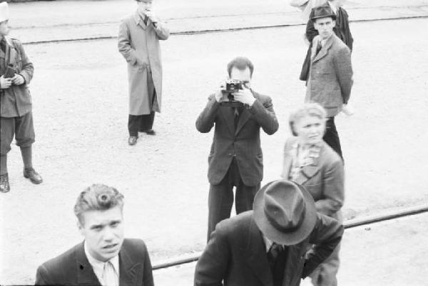 Viaggio in Jugoslavia. Lubiana: viaggiatori alla stazione. In secondo piano un fotografo che riprende la scena