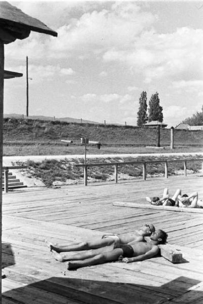 Viaggio in Jugoslavia. Zagabria: due giovani prendono il sole sdraiati sulle terrazze che costeggiano gli argini del fiume Sava