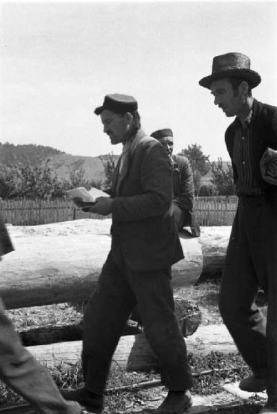 Viaggio in Jugoslavia. Vhrovine: uomini croati camminano lungo i binari della ferrovia