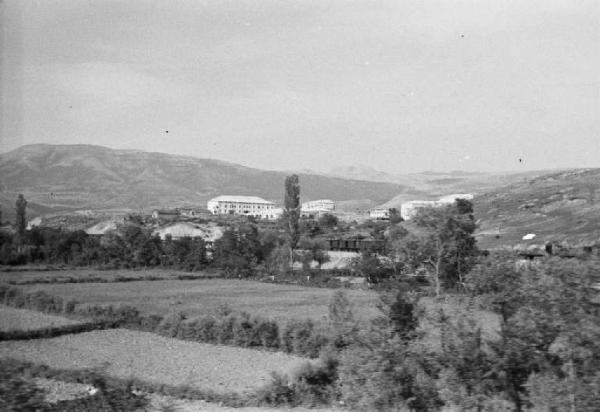 Viaggio in Jugoslavia. Verso Sebenico: veduta di un borgo rurale dal finestrino del treno