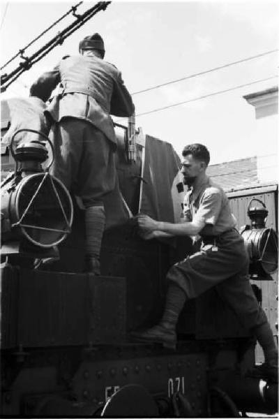 Campagna di Russia. Bolzano - stazione ferroviaria - treno in partenza per il fronte russo - militari appendono la bandiera nazista sulla locomotrice