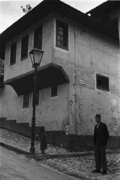 Viaggio in Jugoslavia. Sarajevo: un uomo sosta ai piedi di una abitazione