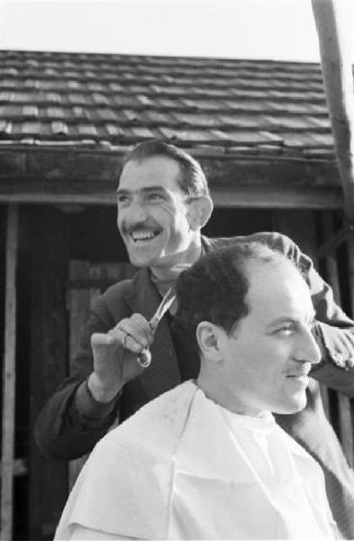 Internamento in Svizzera. Horriwil - Scene di vita quotidiana all'interno del campo, un uomo taglia i capelli a un compagno