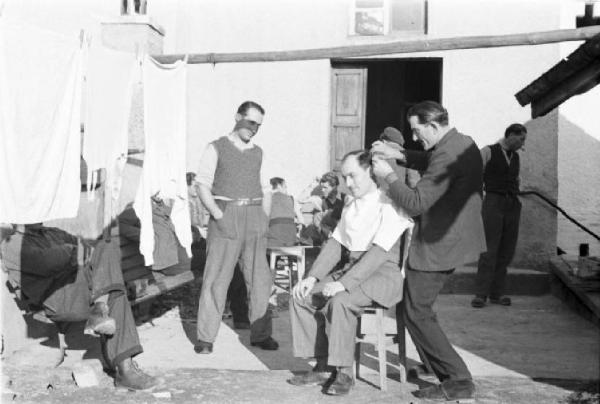 Internamento in Svizzera. Horriwil - Scene di vita quotidiana all'interno del campo, un uomo taglia i capelli a un compagno