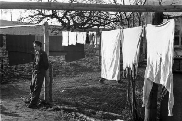 Internamento in Svizzera. Horriwil - Scene di vita quotidiana all'interno del campo, un uomo appoggiato a un palo e biancheria stesa ad asciugare
