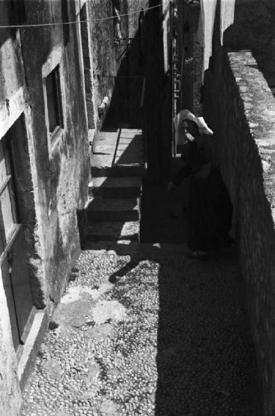 Viaggio in Jugoslavia. Dubrovnik (Ragusa): scene di vita quotidiana - ripresa dall'alto: donna del luogo lungo la stretta gradinata di un vicolo