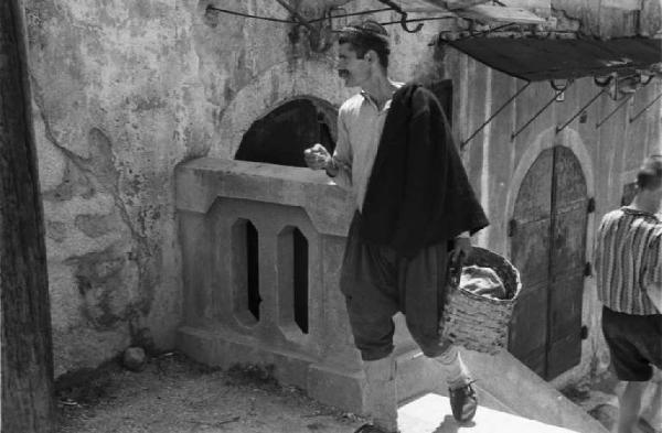 Viaggio in Jugoslavia. Mostar: scene di vita quotidiana - uomo che cammina tra i vicoli del paese