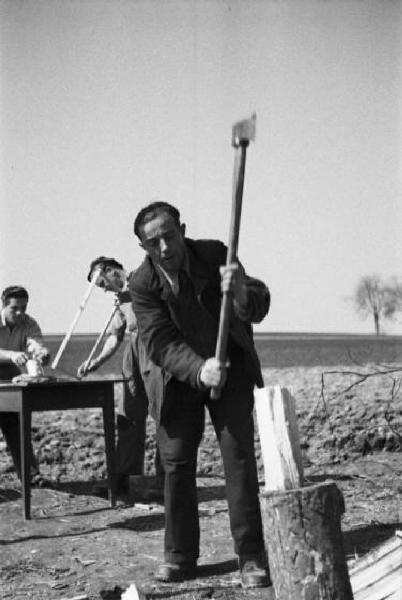 Internamento in Svizzera. Horriwil - Scena di vita quotidiana all'interno del campo, costruzione di una baracca - Compagni che spaccano la legna e costruiscono i telai delle finestre