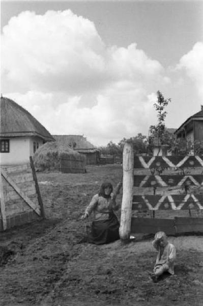 Campagna di Russia. Bessarabia - Riscani - bambino seduto per terra e donna