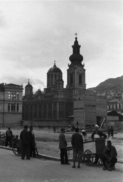 Viaggio in Jugoslavia. Sarajevo: gruppi di cittadini a passeggio per le vie della città - sullo sfondo si riconosce la cattedrale