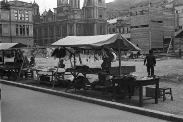 Viaggio in Jugoslavia. Sarajevo: scorcio delle bancarelle nella piazza della cattedrale durante il mercato - si intravede sullo sfondo la cattedrale