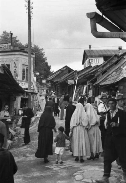 Viaggio in Jugoslavia. Sarajevo: scorcio di una via commerciale all'interno del centro abitato gremita di persone