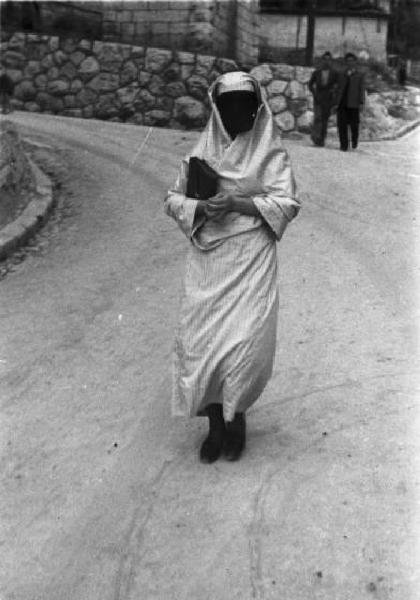 Viaggio in Jugoslavia. Sarajevo: donna bosniaca in abitii tradizionali cammina sopra un sentiero