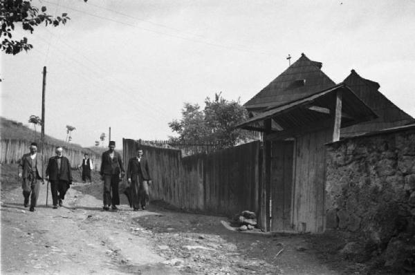Viaggio in Jugoslavia. Yaitze: scorcio dell'abitato nei pressi di un sentiero sterrato con gruppi di viandanti