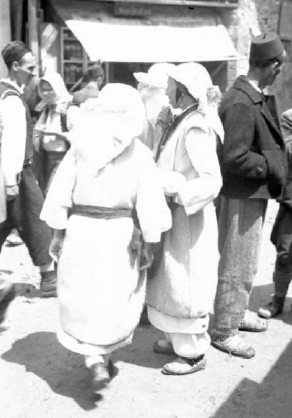 Viaggio in Jugoslavia. Yaitze: scorcio del borgo affollato dagli abitanti - in primo piano si riconosce una coppia di donne in costume locale