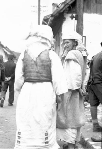 Viaggio in Jugoslavia. Yaitze: coppia di donne bosniache in costume locale al mercato - scorcio di spalle