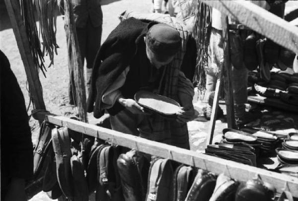 Viaggio in Jugoslavia. Yaitze: bancarella di cappelli - scorcio ravvicinato con il proprietario in primo piano