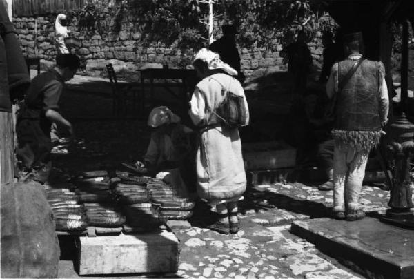 Viaggio in Jugoslavia. Yaitze: gruppo di donne artigiane sistemano la loro merce nella zona del mercato
