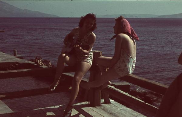 Viaggio in Jugoslavia. Senj (Segni): coppia di giovani ragazze suanano la chitarra sul lungomare