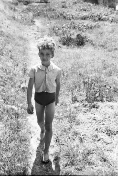 Roma - isola Tiberina. Un giovane fanciullo lungo un sentiero che porta al fiume Tevere