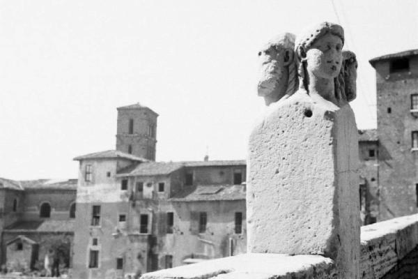 Roma - isola Tiberina. Scorcio da uno dei ponti di accesso con una pietra adornativa a quattro faccie in primo piano