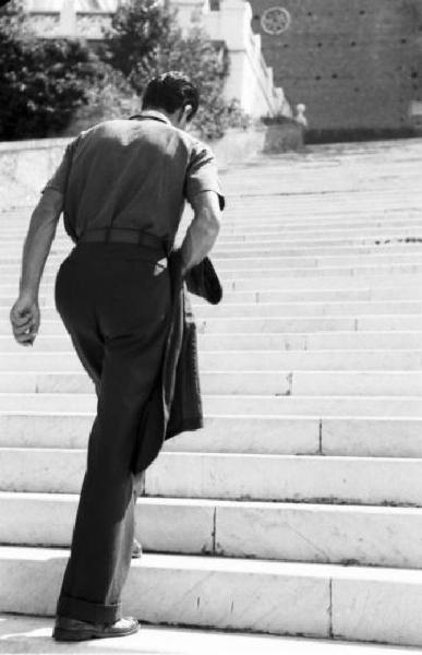Roma - piazza del Campidoglio. Un uomo vestito elegantemente sale la scalinata in direzione della piazza