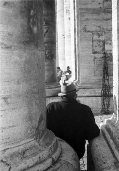 Roma. Piazza San Pietro. Scorcio del colonnato con persona seduta tra le colonne
