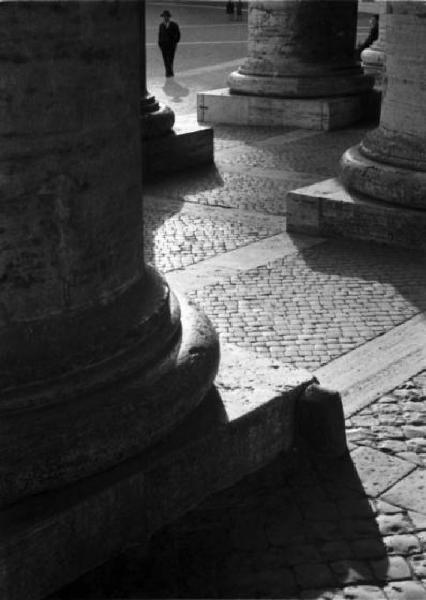 Roma. Piazza San Pietro. Scorcio del colonnato. Sullo sfondo una figura maschile passeggia nella piazza