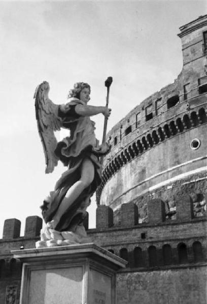 Roma. Ponte Sant'Angelo - una delle dieci statue di angeli che decorano le spallette del ponte. Alle sue spalle è visibile parte del castello in origine mausoleo