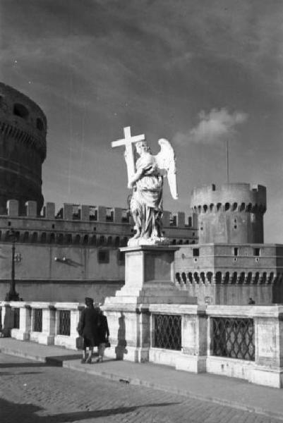 Roma. Scorcio di Ponte Sant'Angelo con una delle dieci statue di angeli che decorano le spallette del ponte. Sullo sfondo è visibile in parte il castello in origine mausoleo