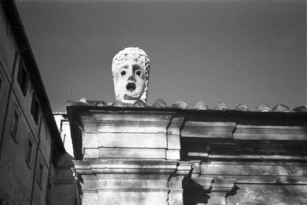 Roma. Maschera decorativa posta lungo il cornicione del tetto di un edificio