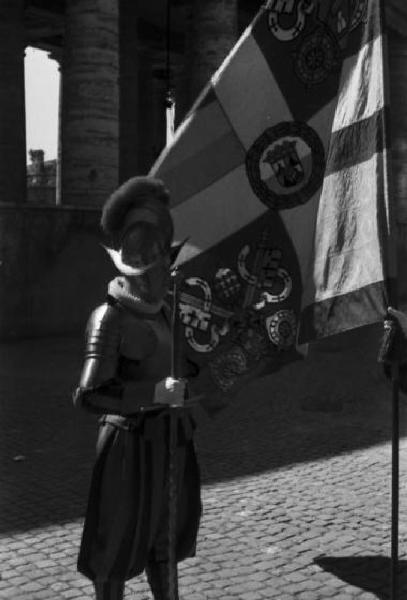 Roma. Città del Vaticano. Guardia svizzera in uniforme di gala accanto alla bandiera pontificia
