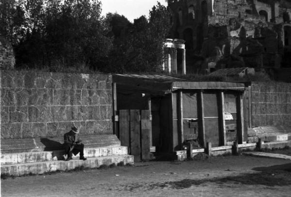 Roma. Baracca addossata alle mura - uomo seduto