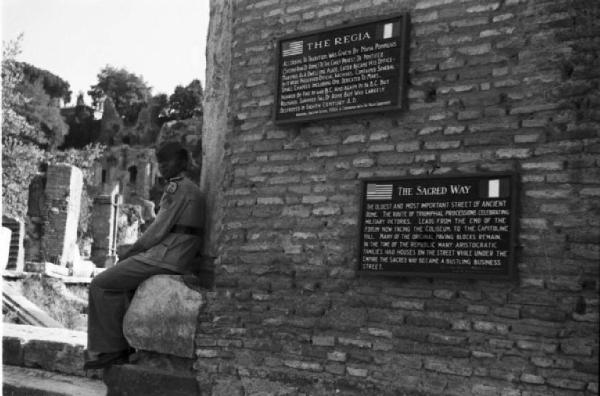 Roma - Soldato delle truppe americane seduto accanto a un muro che riporta un'iscrizione in inglese relativa alla Via Sacra