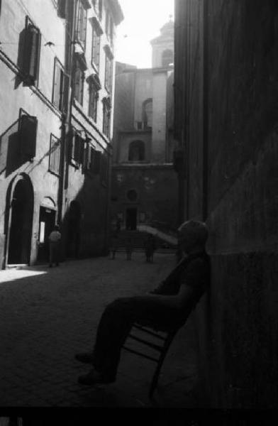 Roma - Vicolo - uomo anziano si dondola su una seggiola