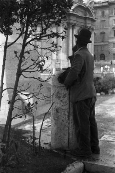 Roma - Uomo di spalle sul ciglio della strada osserva alcuni edifici della città