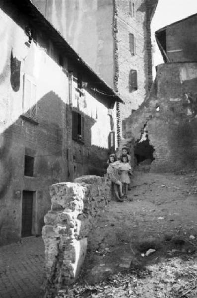 Italia Dopoguerra. Roma - Quartiere Trastevere - gruppo di bambine accanto a un edificio semidistrutto