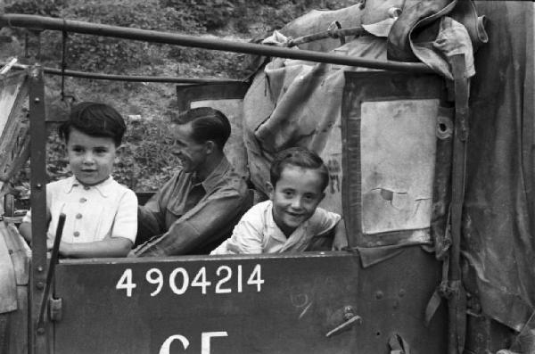 Italia Dopoguerra. Lago Maggiore - Reno - Truppe di liberazione neozelandesi, militare in una camionetta in compagnia di due bambini