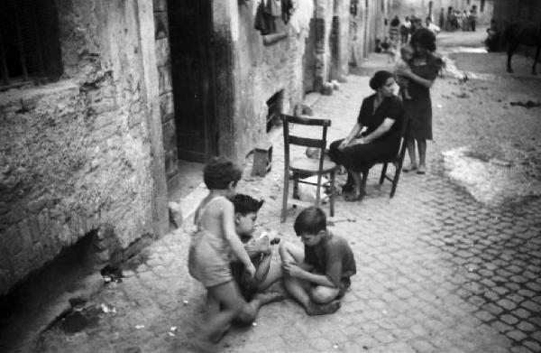 Italia Dopoguerra. Roma - Quartiere Trastevere - vita di strada - bambini che giocano e donne