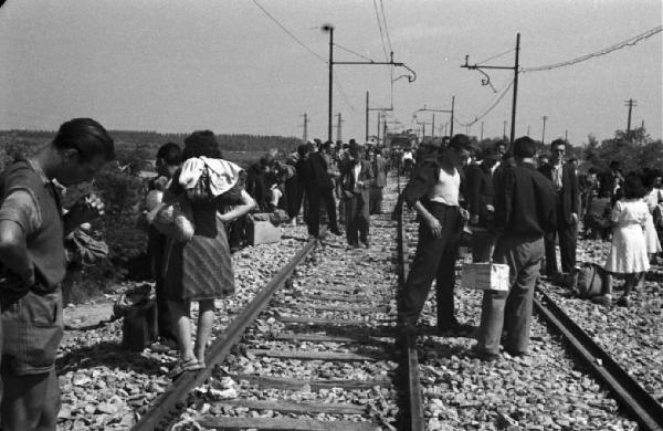 Italia Dopoguerra. Viaggio da Milano a Savona - Passeggeri del treno in attesa lungo i binari