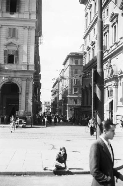 Italia Dopoguerra. Roma - piazza - bambina seduta sul marciapiede