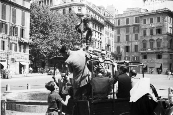 Italia Dopoguerra. Roma - Scorcio di una piazza - In primo piano camionetta militare con gruppo di uomini a bordo