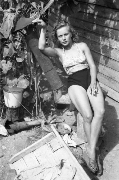 Italia Dopoguerra. Milano - Periferia - Baraccopoli - Ritratto femminile, giovane donna che posa all'esterno di una baracca - Norma Barbieri "la lavandaia vamp"