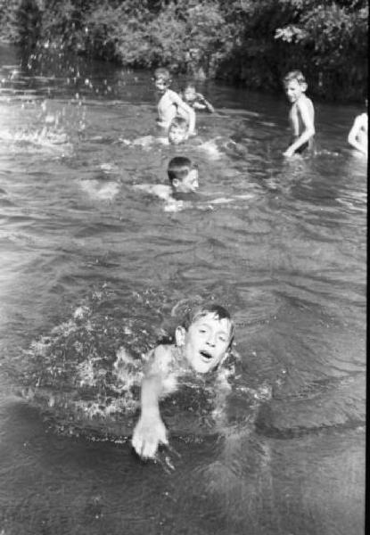 Milano - Naviglio - gruppo di bambini nuota nell'acqua del canale