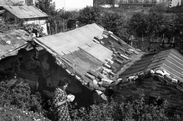 Italia Dopoguerra. Milano - Periferia - Scorcio di una baraccopoli - I tetti di lamiera ancorati tramite sassi