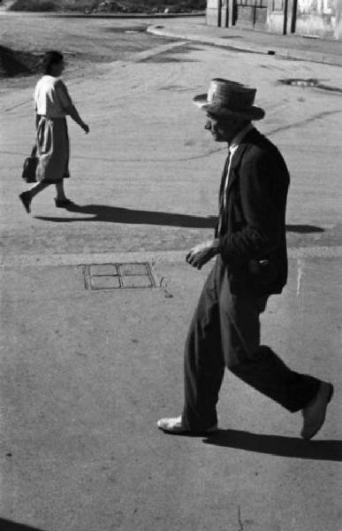 Italia Dopoguerra. Milano. Uomo con cappello che passeggia per una via cittadiina